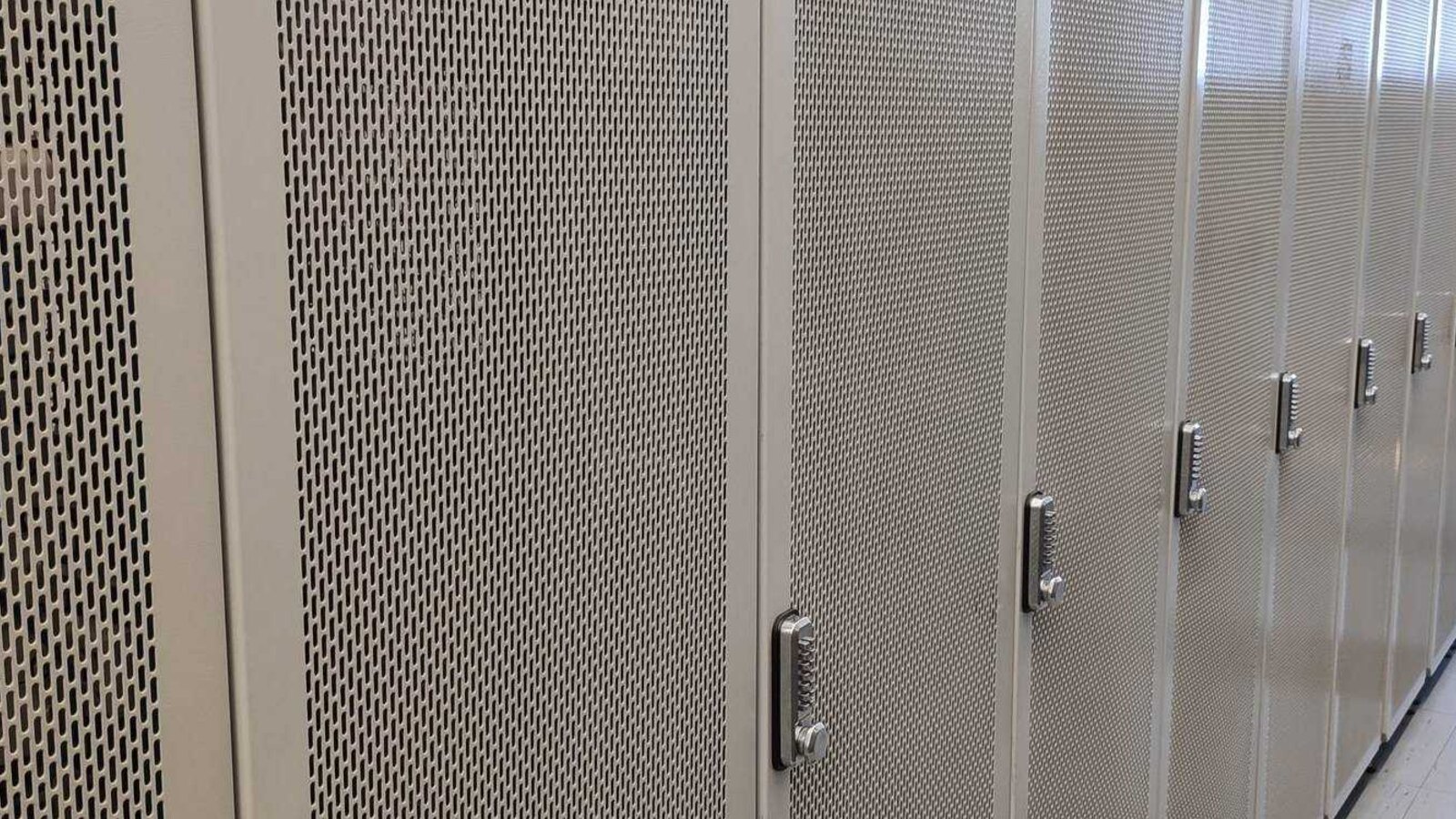 White server cabinets in a data hall with glass aisle ceiling
